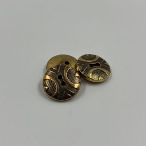 Coat button, brass with shield like pattern